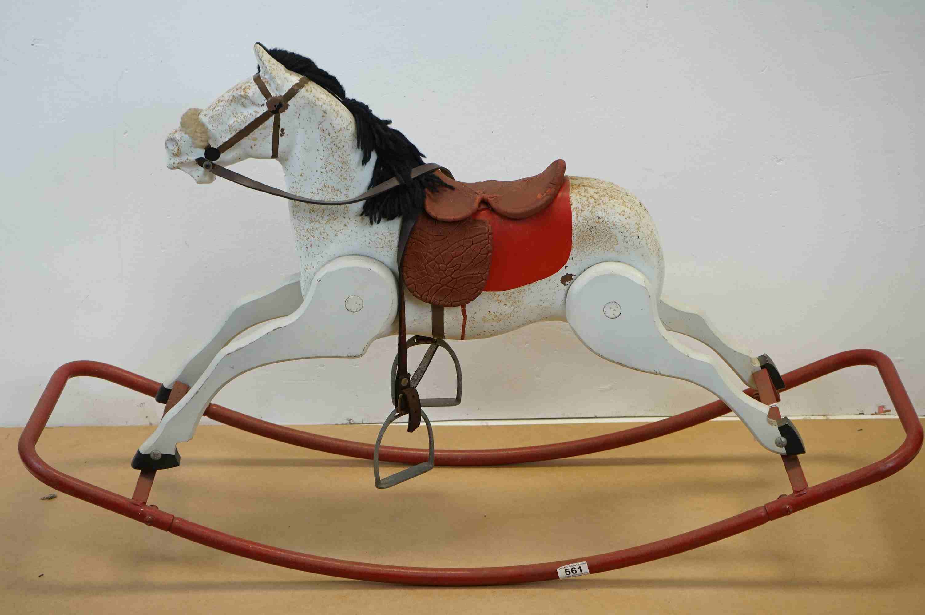 A vintage white rocking horse on red metal runners.