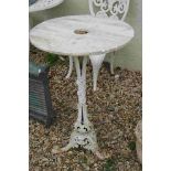 A vintage cast iron outdoor table with alabaster top.