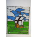 A large stained glass leaded window of a sailing ship. Measures approx 76cm x 60cm.