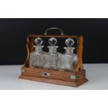 19th century Oak Bound Tantalus of small proportions containing three cut glass bottles with