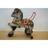 A vintage metal Childs push along horse toy.