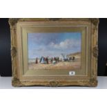 Swept gilt framed oil painting of a Victorian beach scene with figures & beach huts