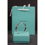 A Tiffany & Co 925 sterling silver bangle complete with box and gift bag.