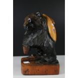 Hand carved brown bear with fish on side, on a carved wooden stand