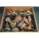 A box containing a collection of furniture feet, finials and wooden curtain rings of various sizes.