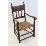 Arts and Crafts Turners style Oak Elbow Chair with spindle back and rush seat, 100cms high x 55cms