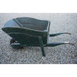 A large wooden green painted wheelbarrow. measures approx 150cm in length.