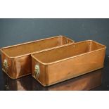 A pair of copper rectangular planters with brass lion head handles.