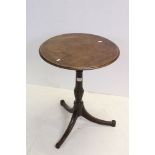 George III Mahogany Circular Wine Table raised on a turned column support with three splayed legs,