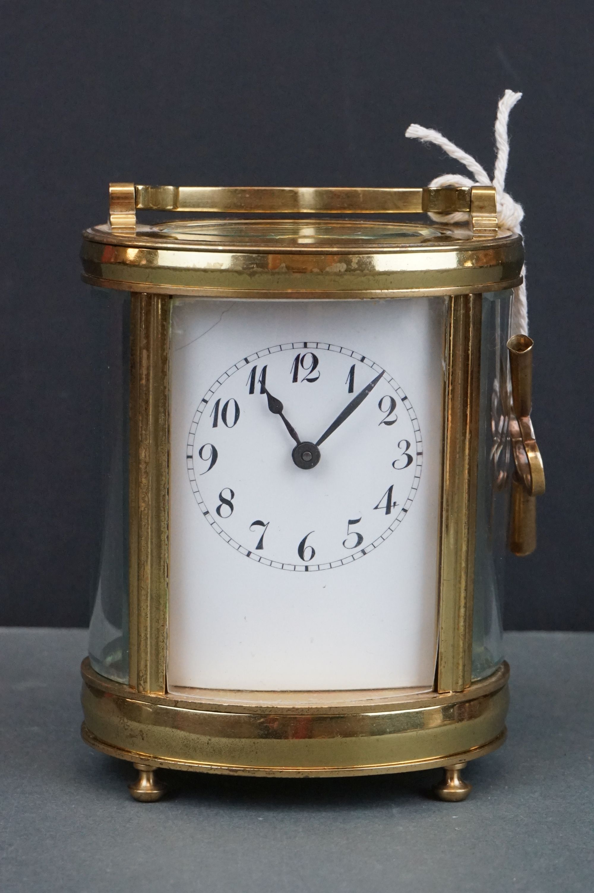 An antique brass cased carriage clock with white enamel dial, complete with key.