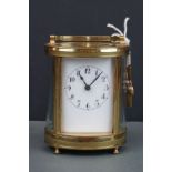 An antique brass cased carriage clock with white enamel dial, complete with key.