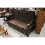 19th century Oak Hall Bench / Settle, the three panel back heavily carved with flowers and