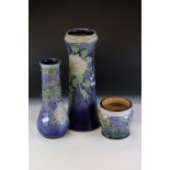 Two Royal Doulton Stoneware Vases with tube-lined decoration of flowers on a blue ground together