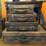 4 x matching antique leather suitcases of graduating size in what appears to be a set of 4, and 1