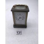 Maple & Co a brass bound carriage clock with enamel dial, movement runs for 1 minute approx