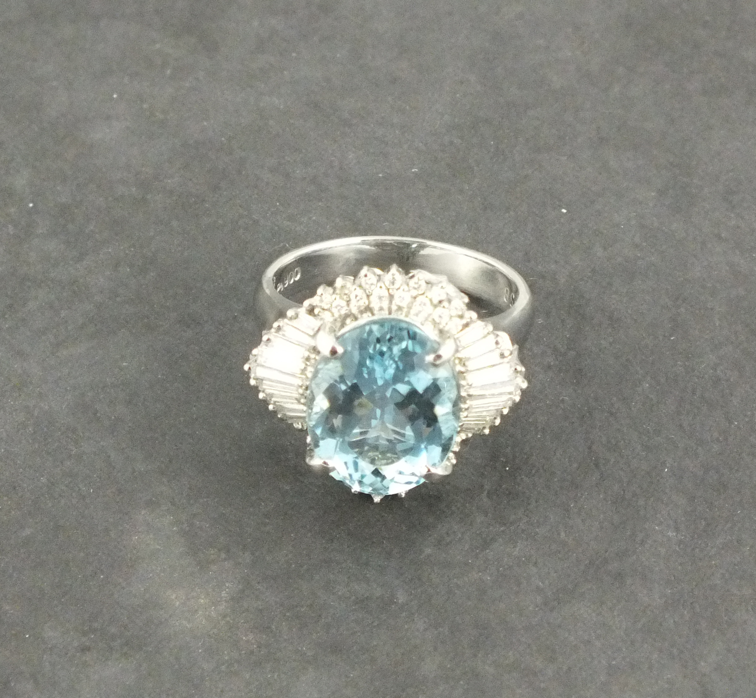 A large aquamarine and diamond set dress ring,  the oval central stone approx. 5.05ct, with a