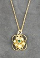 An Edwardian emerald and seed pearl pendant, the cluster on a rope twist round on a 9ct yellow