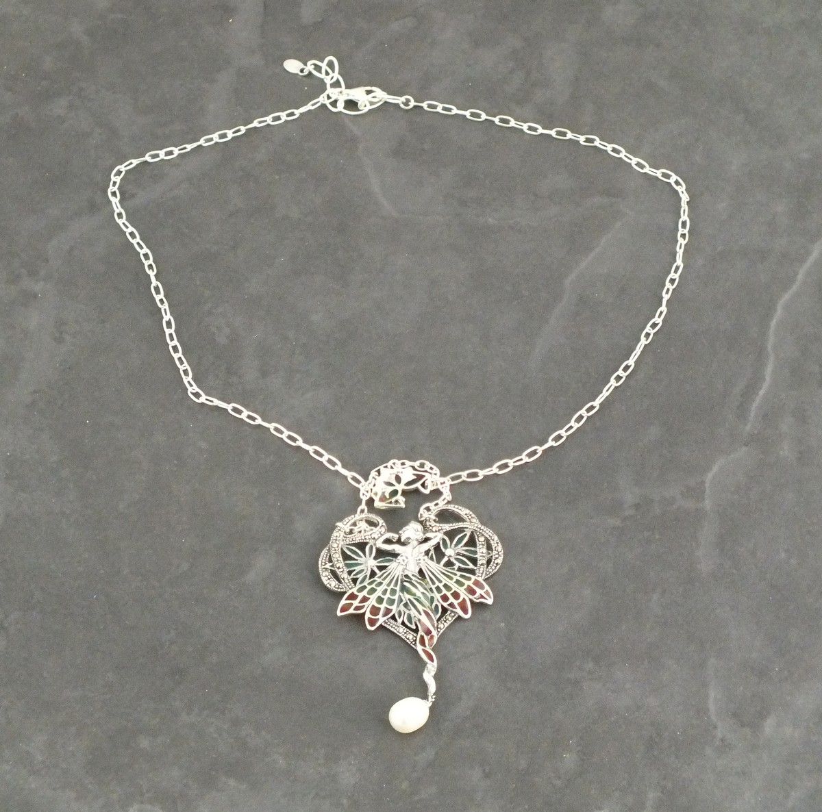 A plique-de-jour necklace, in the Art Nouveau style, modelled as a fairy, with a pearl suspended