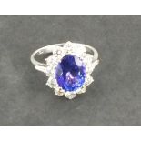 A tanzanite and diamond dress ring, the oval centre stone within a band of diamonds, set in 18ct