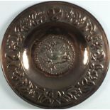 An early 20th Century copper charger, probably Hayle, the centre decorated with a bird on a branch