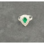A emerald and diamond set dress ring, the pear shaped central stone set in 18ct white gold, 5.2gms