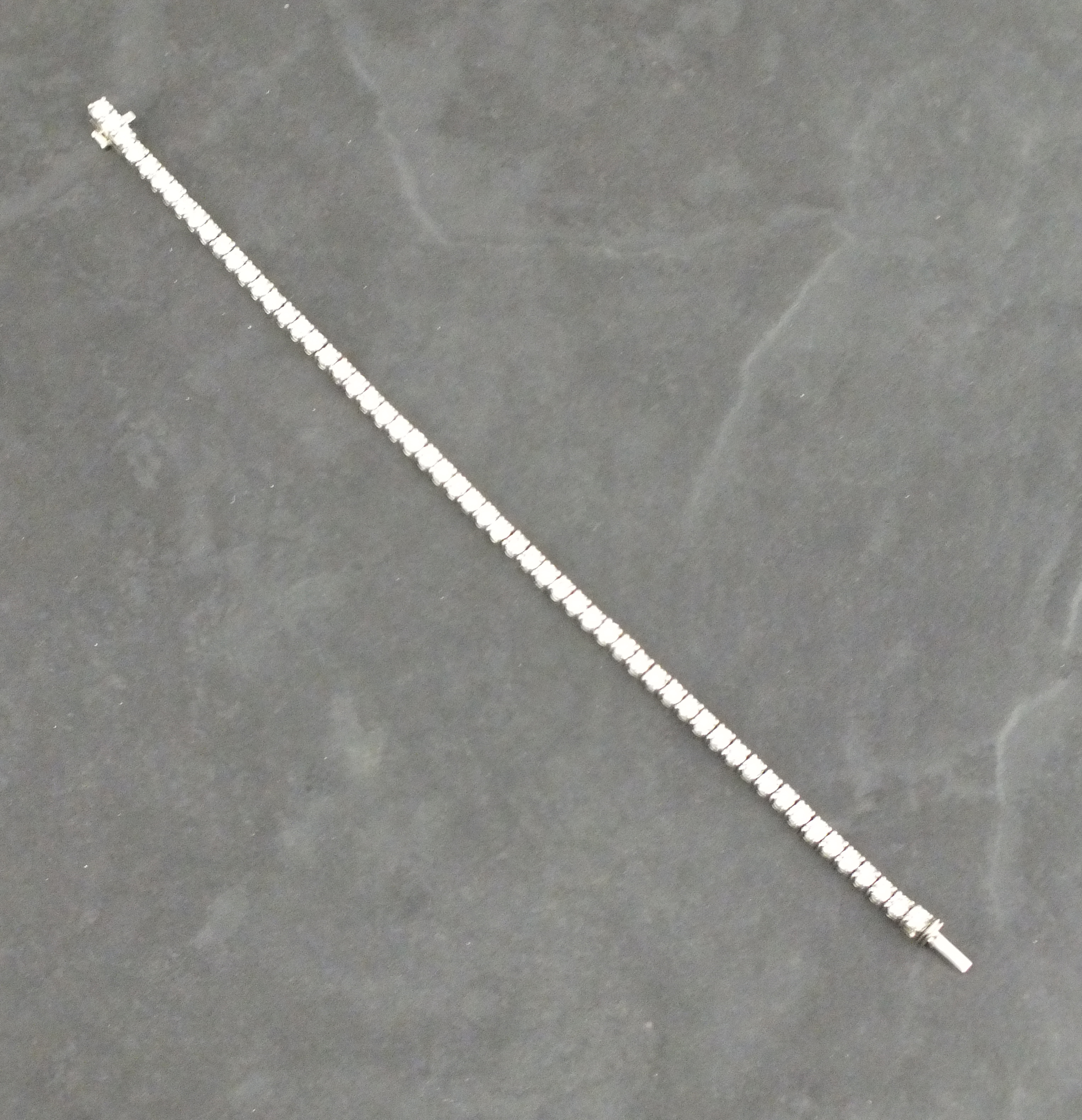 A diamond line bracelet, the brilliant cut stones (approx.  5..04 total weight) claw 18ct white