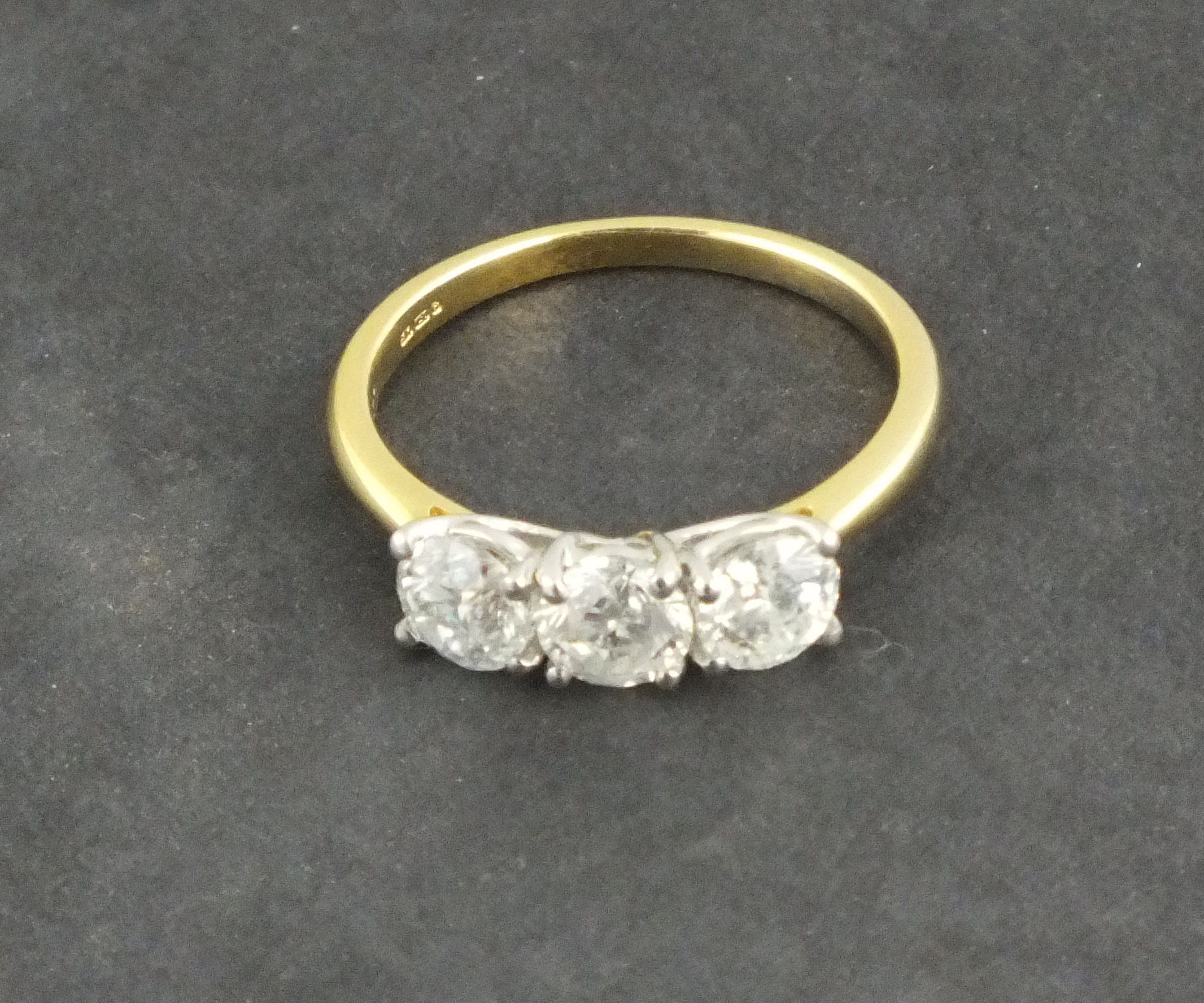 A three stone diamond ring, the brilliant cut stones totalling approx. 1.53ct, set in 18ct yellow