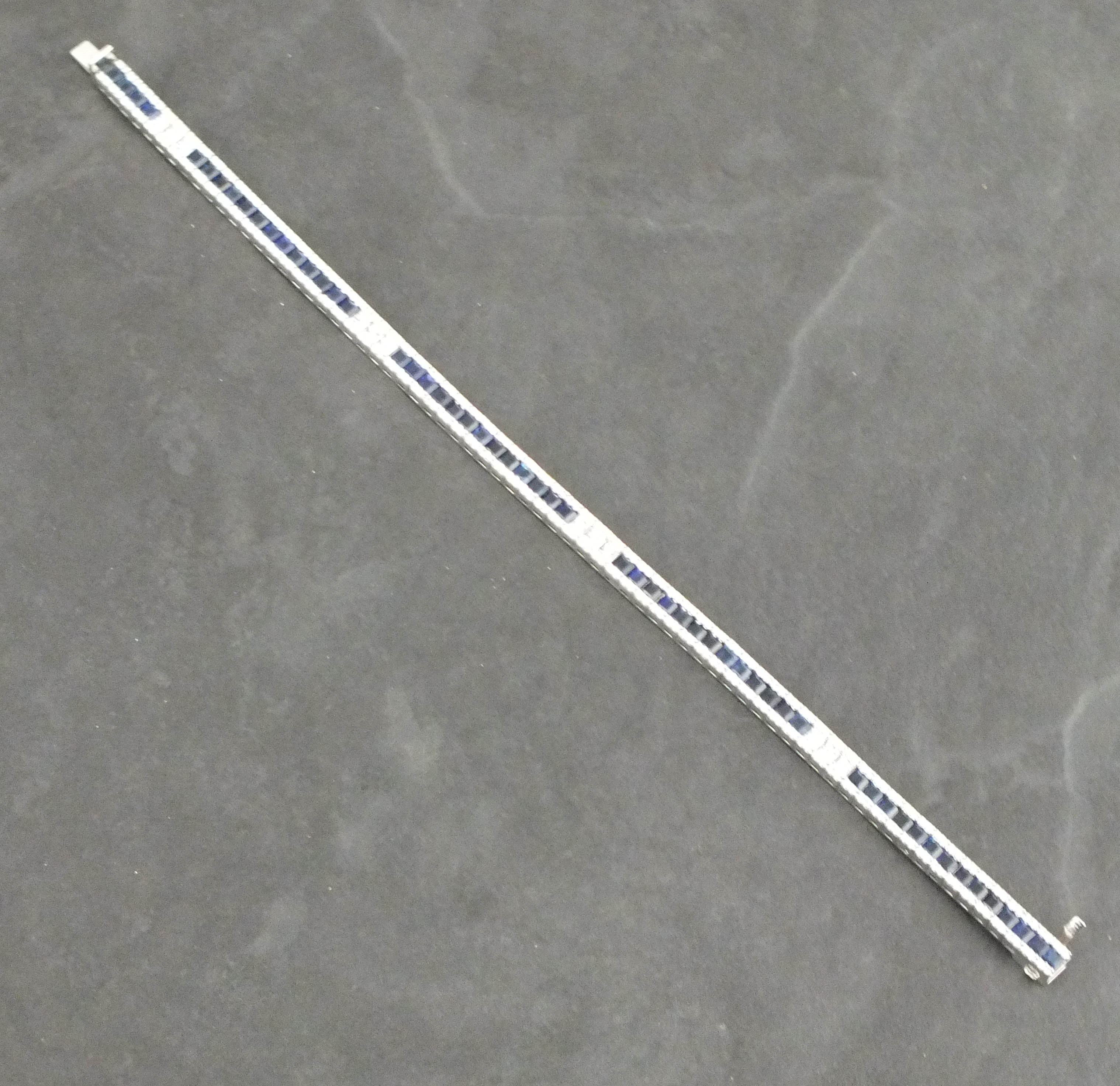 A sapphire  and diamond line bracelet, with princess cut stones in 18ct white gold, 18.4gms