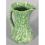 A Syvac Pottery vase, green glazed and decorated in relief with hollyhocks, 8.75" (22cm) high,