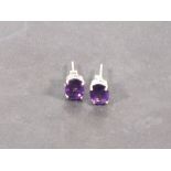 A pair of amethyst ear studs, the oval cut stones claw set in silver