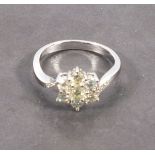 A seven stone diamond ring, the cluster ring in flower form set in 18ct white gold with diamond