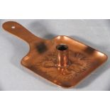 A late 19th Copper chamberstick, possibly Newlyn, of square paddle form, repousse decorated with