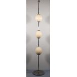 A contemporary floor lamp, of polished steel and incorporating three ostrich eggs to the column,