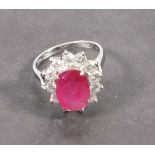 A ruby and diamond dress ring, the oval cut central stone totaling 3.71ct, within a band of diamonds
