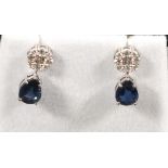 A pair of sapphire and diamond drop ear studs, the pear shaped drops suspended from cluster