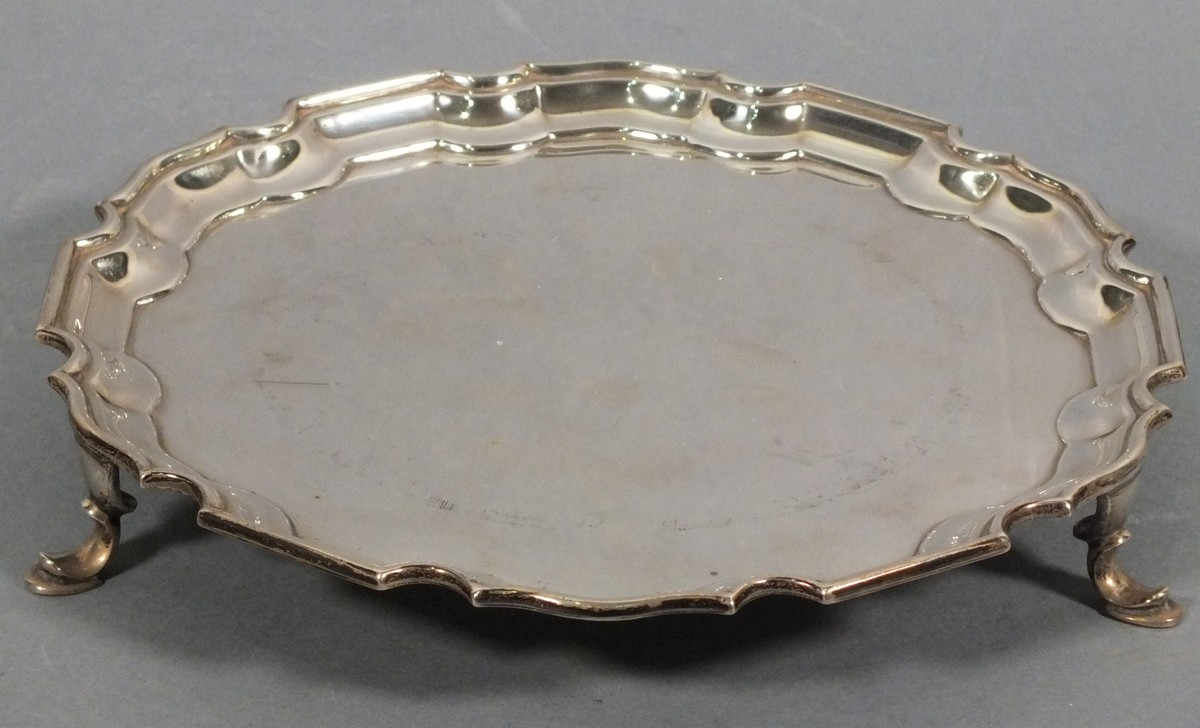 A silver waiter, Sheffield 1958, Mappin & Webb, circular with a piecrust edge, raised on three