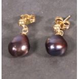 A pair of black pearl ear drops, the asymmetrical beads suspended from 9ct gold studs