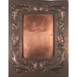 A late 19th/early 20th Century Newlyn copper easel picture frame, rectangular with repousse