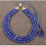 A blue bead necklace, of facetted stones on an adjustable cord, approx 1012.00ct