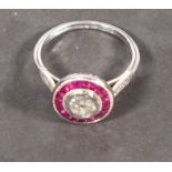 A ruby and diamond dress ring, set in platinum, target style with a central diamond, approx 0.