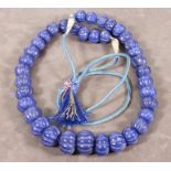A blue bead necklace, the carved stones on two strands and adjustable cord, approx. 930.50ct