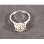 A diamond dress ring, daisy style set with round brilliant cut stones, set in 18ct white gold,