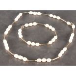 An oval freshwater cultured pearl necklace, of oval beads set between 9ct yellow gold batons,