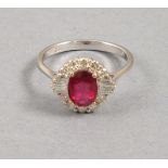 A ruby and diamond cluster ring, set in 18ct white gold, the central stone approx 1.45ct between a