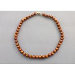 A string of chocolate coloured freshwater pearls, set with an 9ct gold clasp, 44cm long