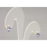 A pair of tanzanite set earstuds, claw set in silver