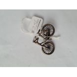 A silver brooch in the form of a bicycle