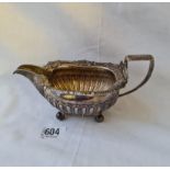 A good quality George III cream jug with shell decorated rim and four ball feet - London 1810 by