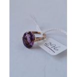 A dress ring set with a large purple stone in 9ct - size K - 2.70gms