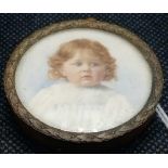 A painted miniature on ivory of a young child in metal frame